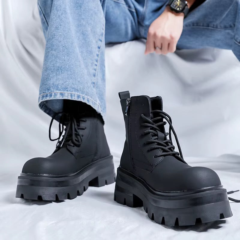 Bottines noires montantes à lacets pour homme, vue de face, avec semelles épaisses crantées et jean bleu.